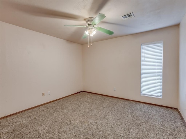 unfurnished room with visible vents, carpet floors, baseboards, and ceiling fan
