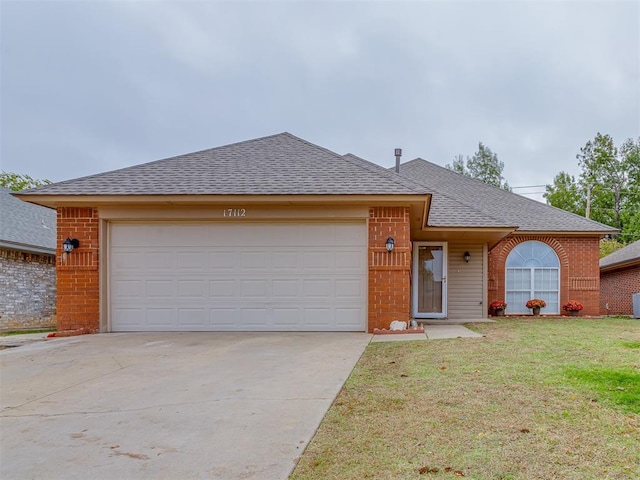 ranch-style home featuring roof with shingles, a front lawn, brick siding, an attached garage, and driveway