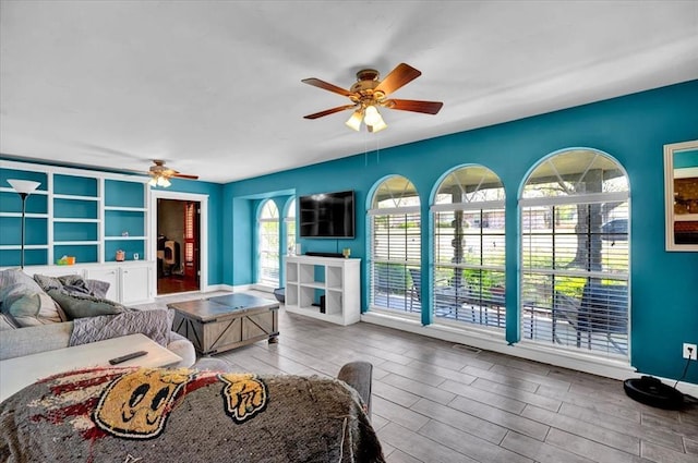 2315 Grisso Dr, Seminole, OK 74868 - living area with visible vents, baseboards, a ceiling fan, and wood finished floors