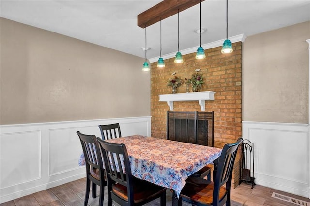 2315 Grisso Dr, Seminole, OK 74868 - dining space featuring a decorative wall, visible vents, a wainscoted wall, and wood finished floors