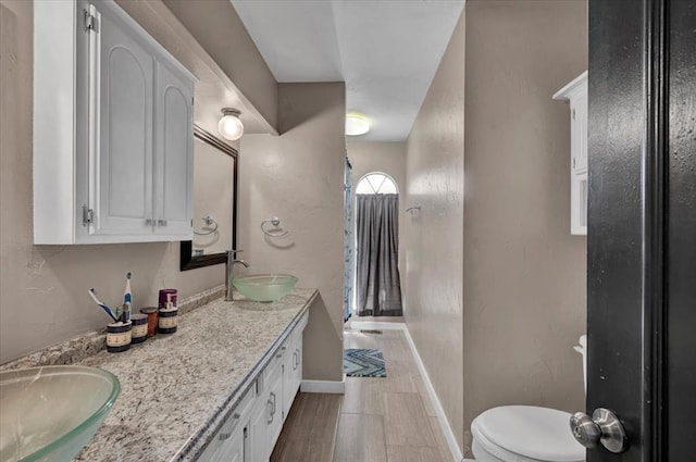 2315 Grisso Dr, Seminole, OK 74868 - full bath with toilet, double vanity, a sink, and baseboards