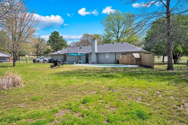 2315 Grisso Dr, Seminole, OK 74868 - back of house featuring a chimney, a patio area, fence, and a lawn