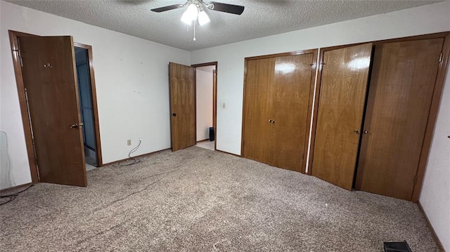 100 N Rockypoint Dr, Edmond, OK 73003 - unfurnished bedroom with carpet floors, multiple closets, a textured ceiling, and a ceiling fan