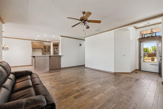 1240 Penny Ln, El Reno, OK 73036 - living room featuring ornamental molding, ceiling fan with notable chandelier, light wood-style flooring, and visible vents