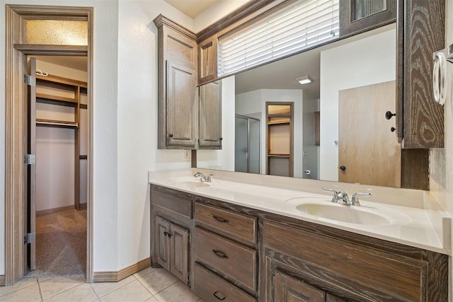 1240 Penny Ln, El Reno, OK 73036 - bathroom with tile patterned floors, a shower stall, a spacious closet, and a sink