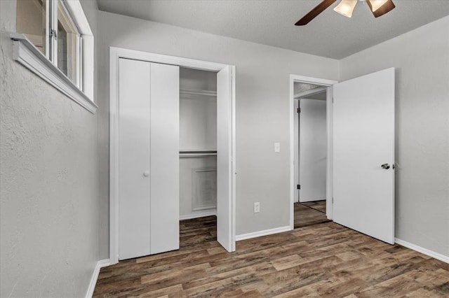 unfurnished bedroom with a closet, baseboards, a ceiling fan, and wood finished floors