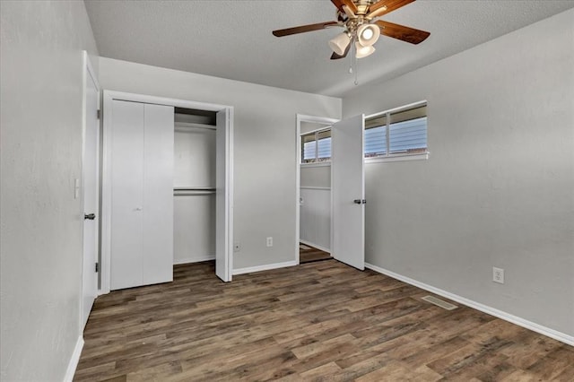 unfurnished bedroom with baseboards, a ceiling fan, wood finished floors, and a textured ceiling