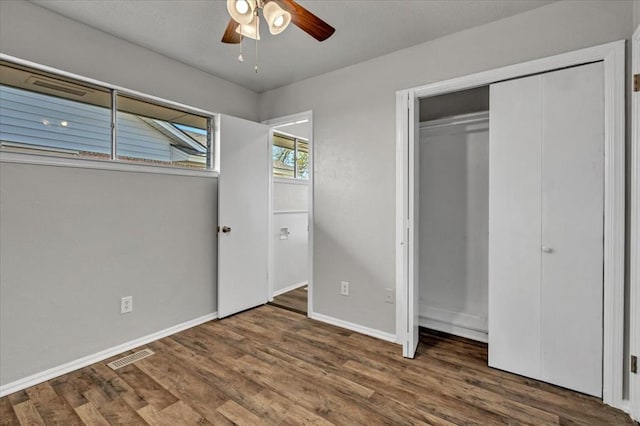 unfurnished bedroom with visible vents, baseboards, a closet, and wood finished floors