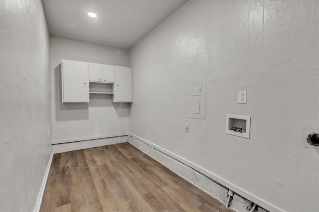 clothes washing area with baseboards, wood finished floors, hookup for a washing machine, and laundry area