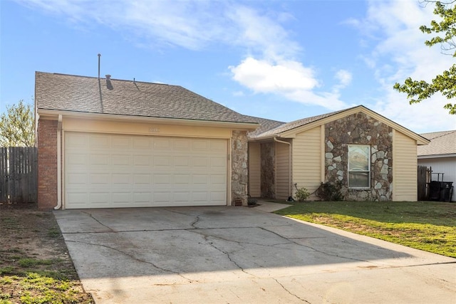 ranch-style house with stone siding, fence, a front lawn, an attached garage, and driveway