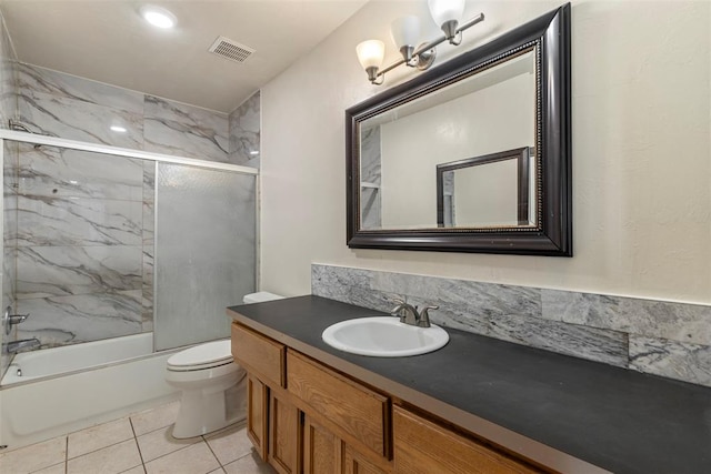 full bathroom featuring visible vents, combined bath / shower with glass door, toilet, vanity, and tile patterned flooring
