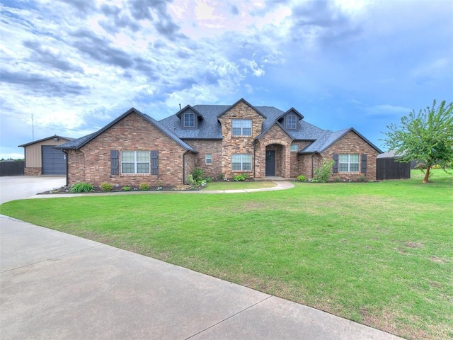 view of front of home featuring a garage, brick siding, a shingled roof, and a front yard