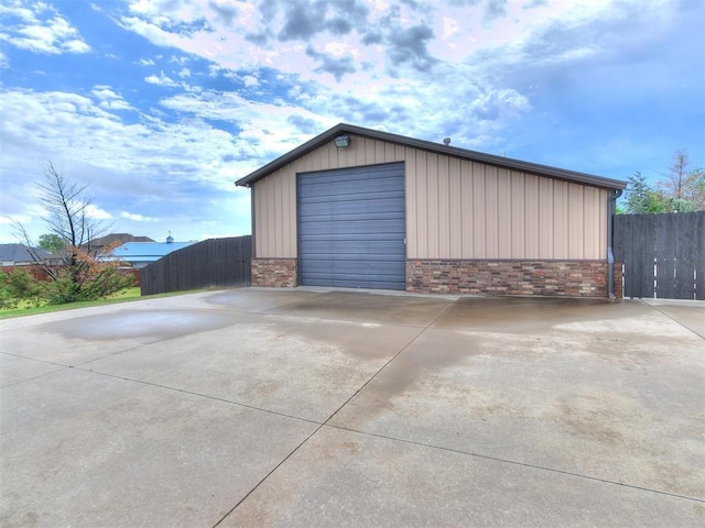 detached garage with fence and concrete driveway