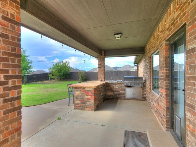 view of patio with grilling area, area for grilling, outdoor dry bar, and a fenced backyard