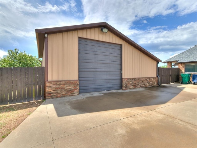 detached garage featuring fence and driveway