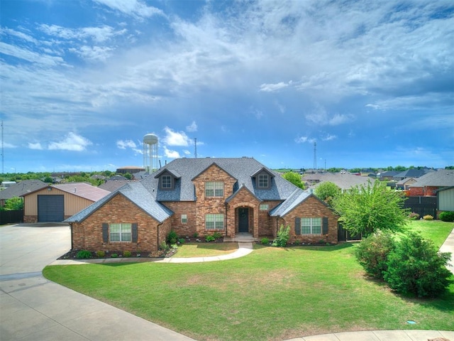 traditional home with a front lawn, a garage, a shingled roof, and fence