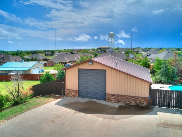 detached garage featuring fence and a residential view