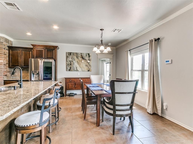 dining area featuring a chandelier, light tile patterned floors, crown molding, visible vents, and baseboards