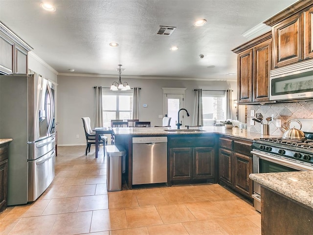 kitchen with a wealth of natural light, stainless steel appliances, backsplash, and a sink