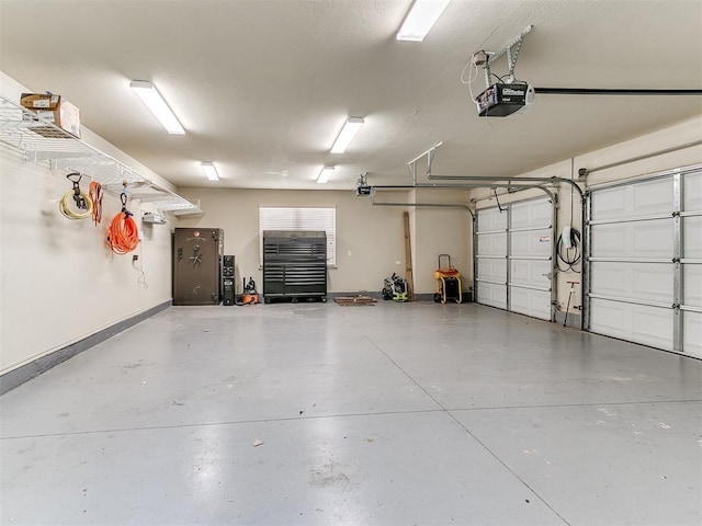 garage featuring a garage door opener and baseboards