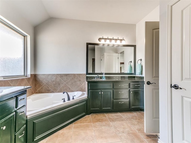 full bathroom with tile patterned floors, a bath, lofted ceiling, and vanity