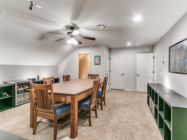 dining room featuring visible vents, a ceiling fan, and light colored carpet
