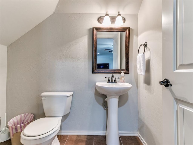 bathroom featuring baseboards, toilet, tile patterned flooring, and a sink