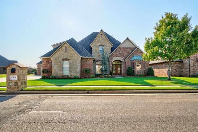 11016 Katie Beth Ln, Oklahoma City, OK 73170 - french provincial home with french doors, stone siding, and a front lawn