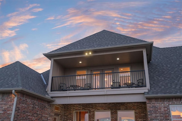 11016 Katie Beth Ln, Oklahoma City, OK 73170 - back of house featuring a balcony, brick siding, and a shingled roof