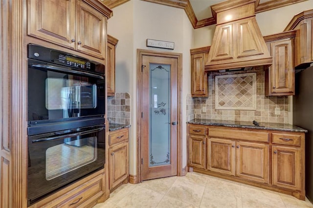 11016 Katie Beth Ln, Oklahoma City, OK 73170 - kitchen with premium range hood, black appliances, dark stone counters, backsplash, and ornamental molding