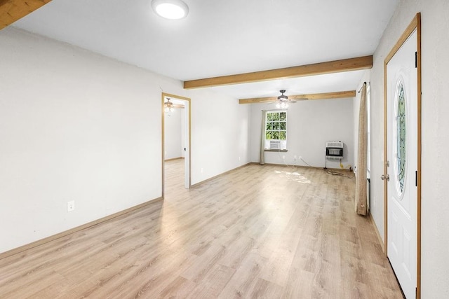 spare room with baseboards, a ceiling fan, heating unit, beam ceiling, and light wood finished floors