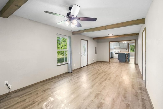 unfurnished living room featuring light wood-style floors, baseboards, beamed ceiling, and ceiling fan