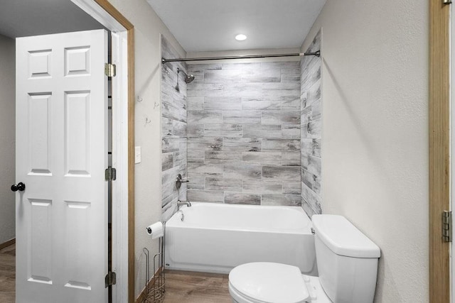 bathroom with toilet, wood finished floors, and bathtub / shower combination