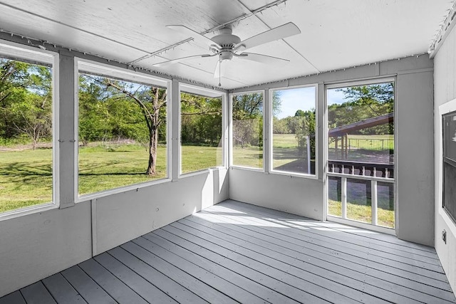 unfurnished sunroom featuring a ceiling fan