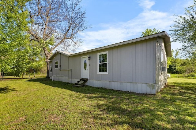 exterior space with entry steps and a lawn