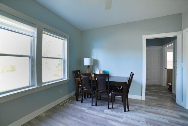 dining area with visible vents, a ceiling fan, baseboards, and wood finished floors