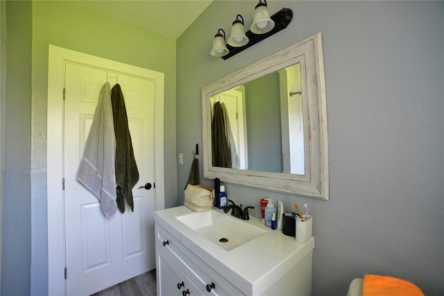 bathroom with wood finished floors and vanity