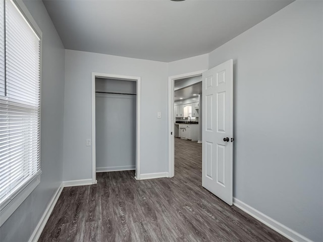 unfurnished bedroom featuring dark wood-type flooring and baseboards