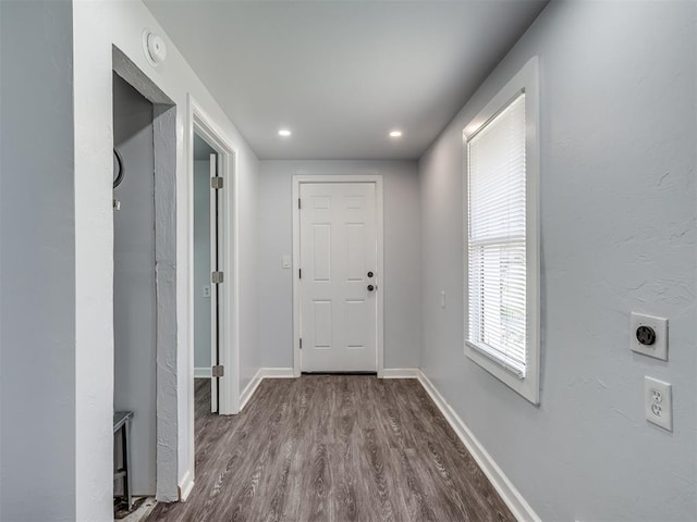 hallway featuring dark wood-style flooring, baseboards, and recessed lighting