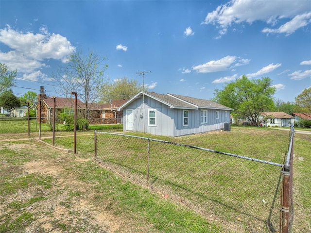 view of side of property featuring a yard, central AC, and fence