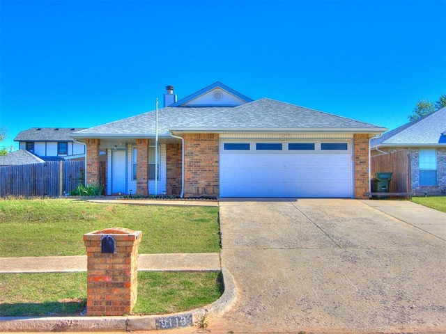 ranch-style home with a front yard, fence, brick siding, an attached garage, and concrete driveway