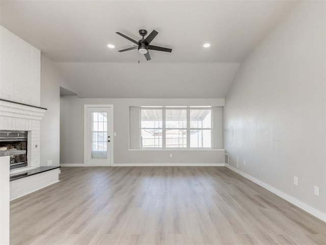 unfurnished living room with a brick fireplace, baseboards, vaulted ceiling, and ceiling fan
