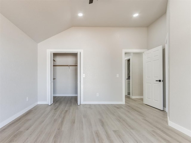 unfurnished bedroom featuring baseboards, light wood-type flooring, and vaulted ceiling