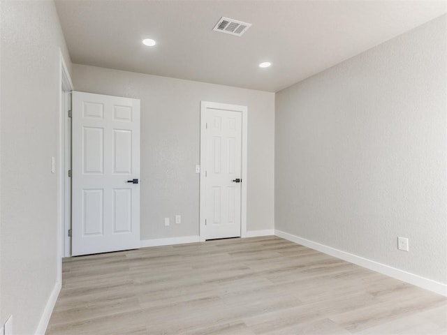 unfurnished room with visible vents, baseboards, light wood finished floors, and recessed lighting