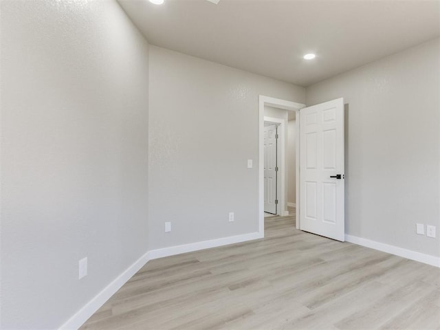 unfurnished room with light wood finished floors, baseboards, and recessed lighting