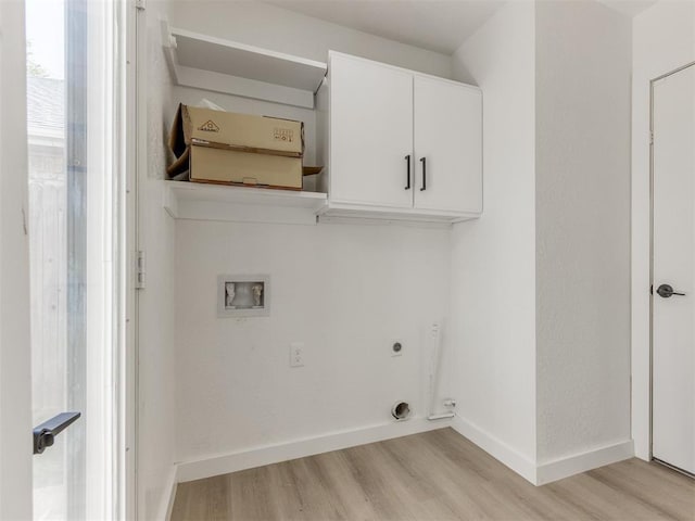 laundry area with baseboards, washer hookup, light wood finished floors, cabinet space, and electric dryer hookup