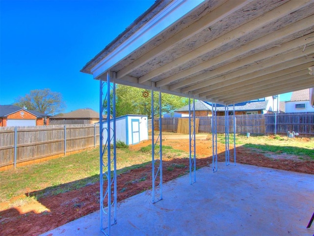 view of patio / terrace with a fenced backyard, a storage shed, and an outbuilding