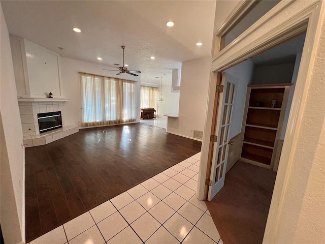 unfurnished living room featuring recessed lighting, tile patterned floors, a fireplace, a ceiling fan, and visible vents