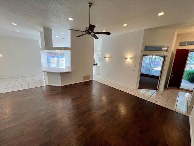unfurnished living room with wood finished floors, a ceiling fan, visible vents, and recessed lighting