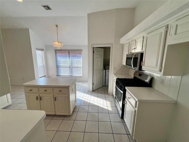 kitchen featuring appliances with stainless steel finishes, light tile patterned floors, light countertops, and lofted ceiling
